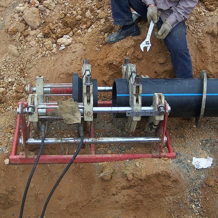 Хар өнгийн ижил PE Цэвэр усны хоолойг дан ганцаар нь барилгын талбай суурилуулж байгаа нь, мөн зурагт нэг ажилчин, нэг хоолой, хэсэг багаж хэрэгсэл харагдана. 